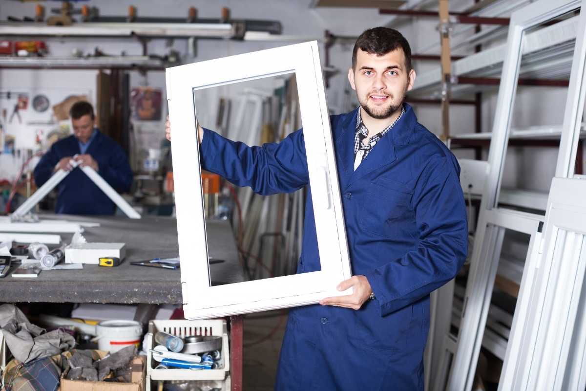 majstor drži pvc prozor u rukama